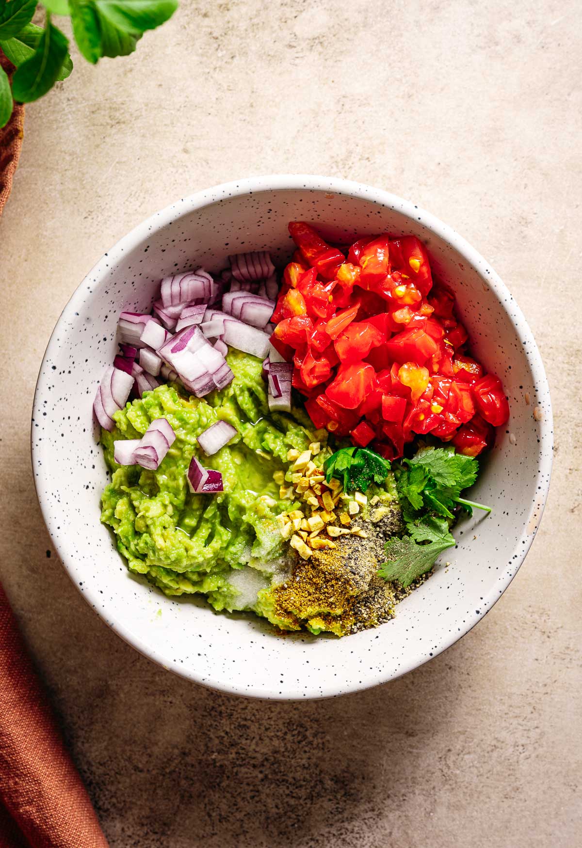 Alle ingredienten voor guacamole bijelkaar in een kom