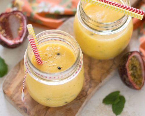 Twee glazen tropische smoothie met mango en passievrucht